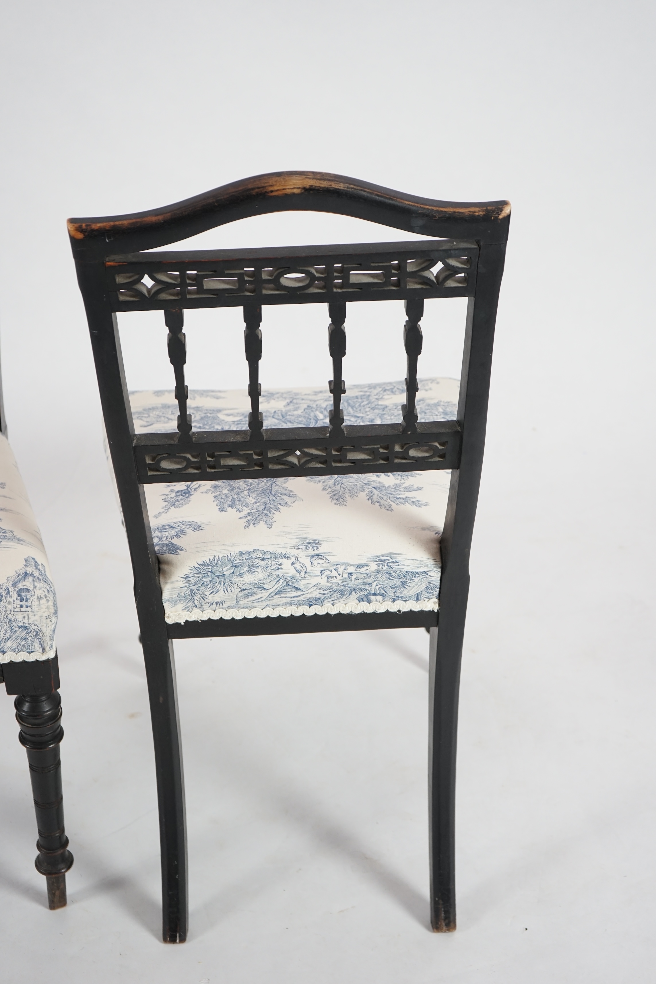 A pair of late Victorian ebonised salon chairs